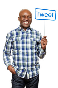 Man holding a social media sign smiling